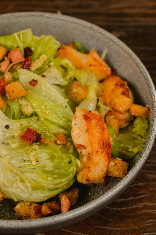 a bowl of chicken and lettuce salad with croutons