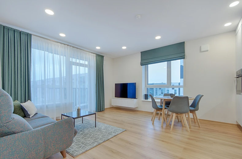 an empty room with white walls, wood flooring, and a blue chair