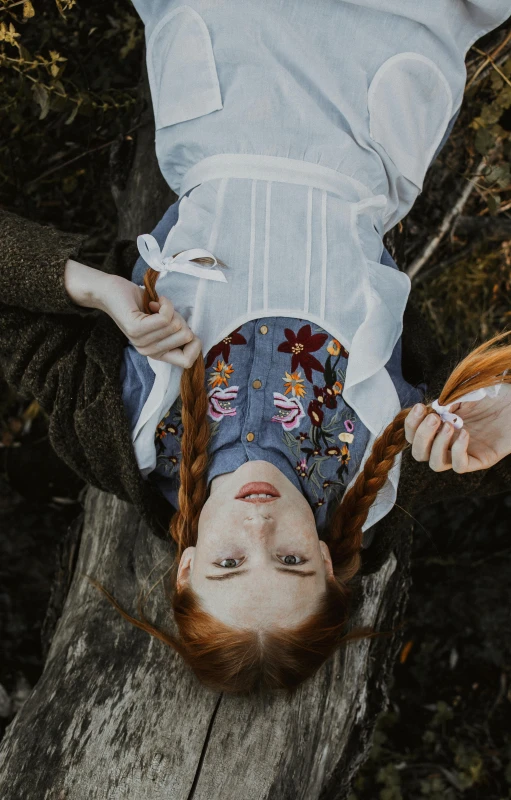 woman in dress laying down on wooden plank