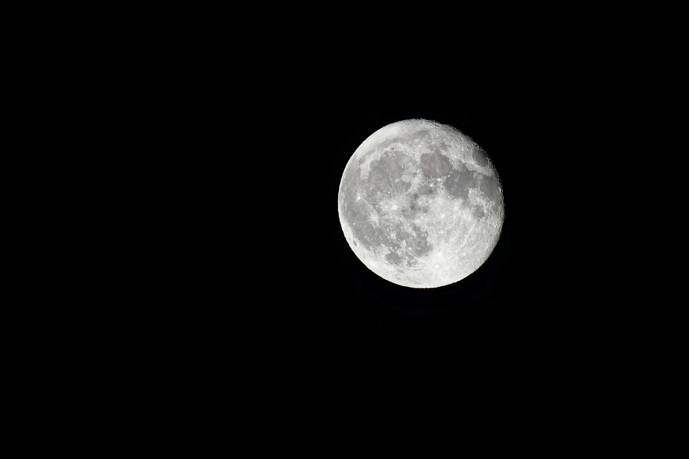 the moon from the sky showing only some visible clouds