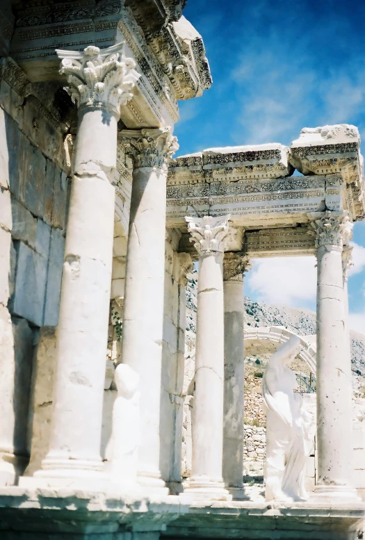 a white sculpture sitting between two stone pillars