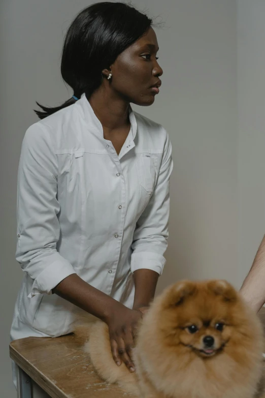 a woman standing next to a brown dog on top of a wooden counter