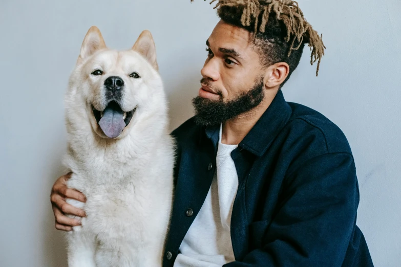 man posing with his dog indoors for a po