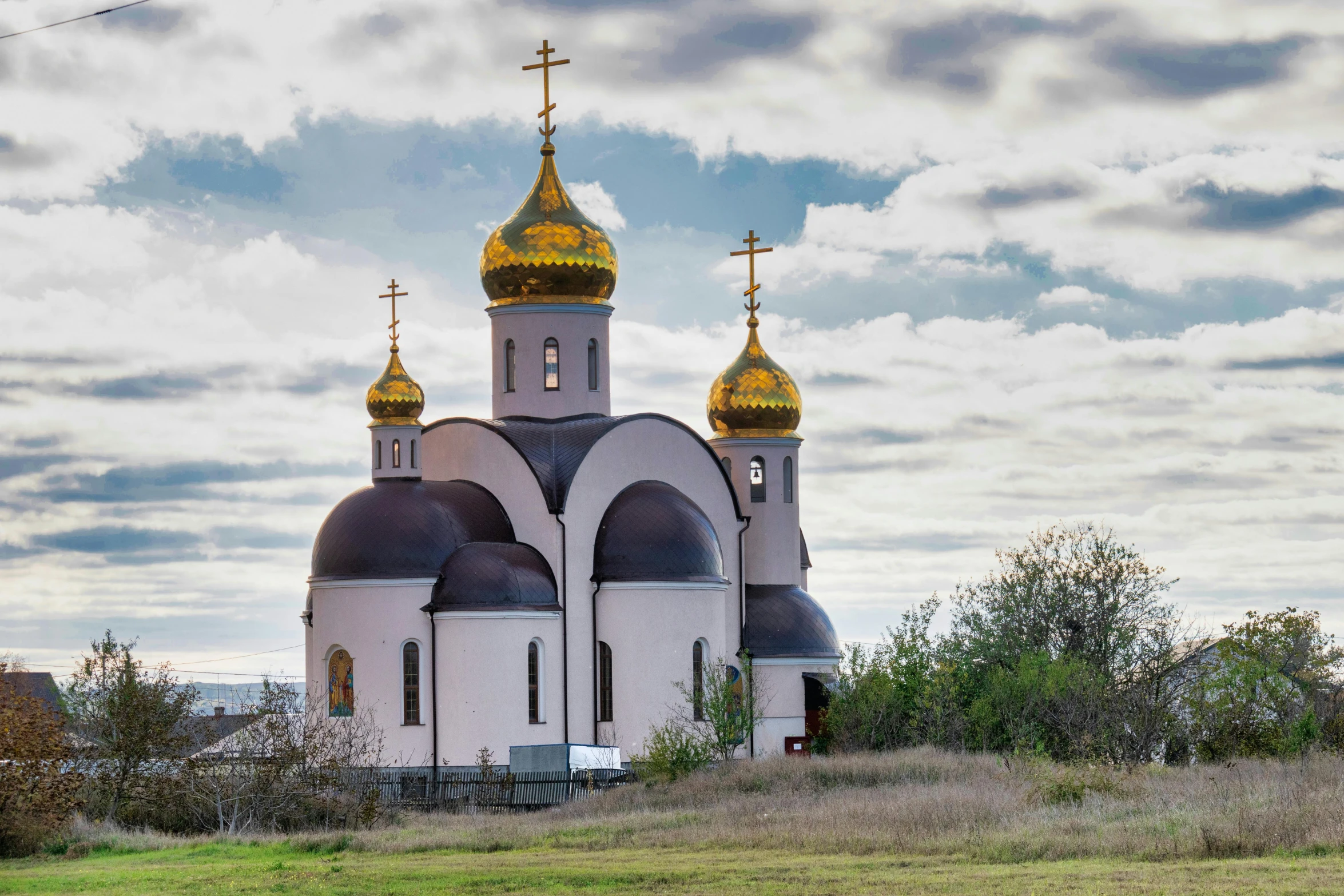 a church with gold steeples in the mountains