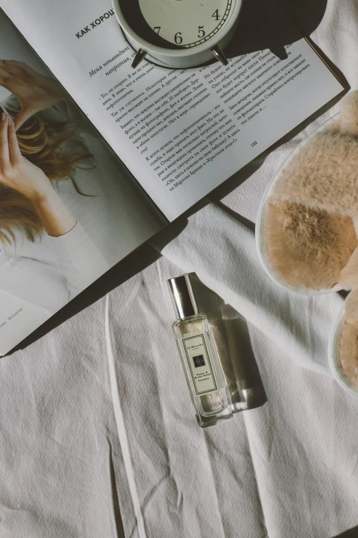 a book and some bottles are laying on the bed