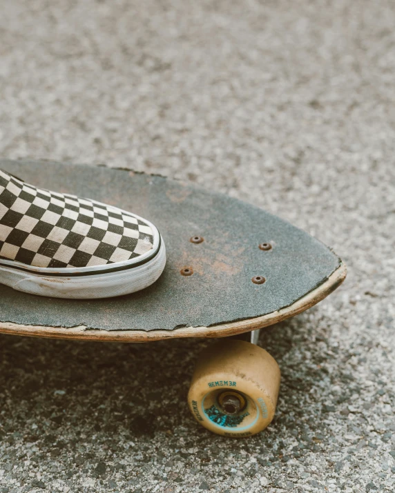 a skateboard with white and black vans