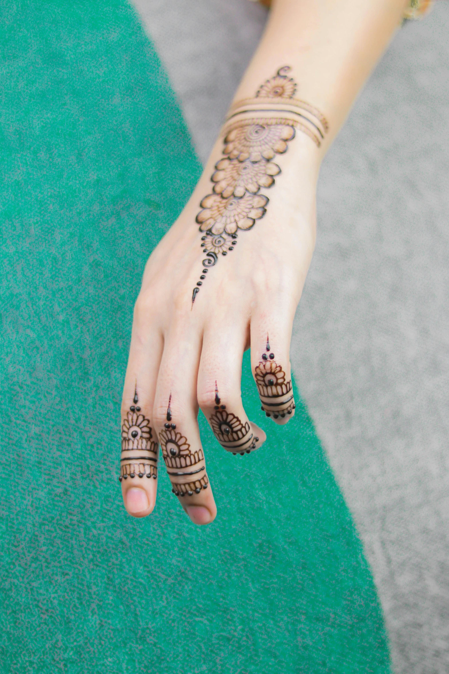 a young woman holding onto a green mat with tattoos on it