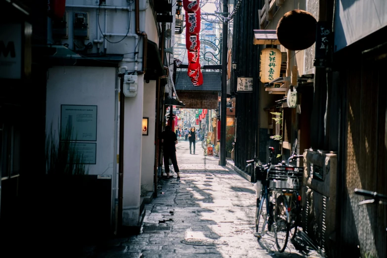 the alley way between some buildings with bicycles parked on the side