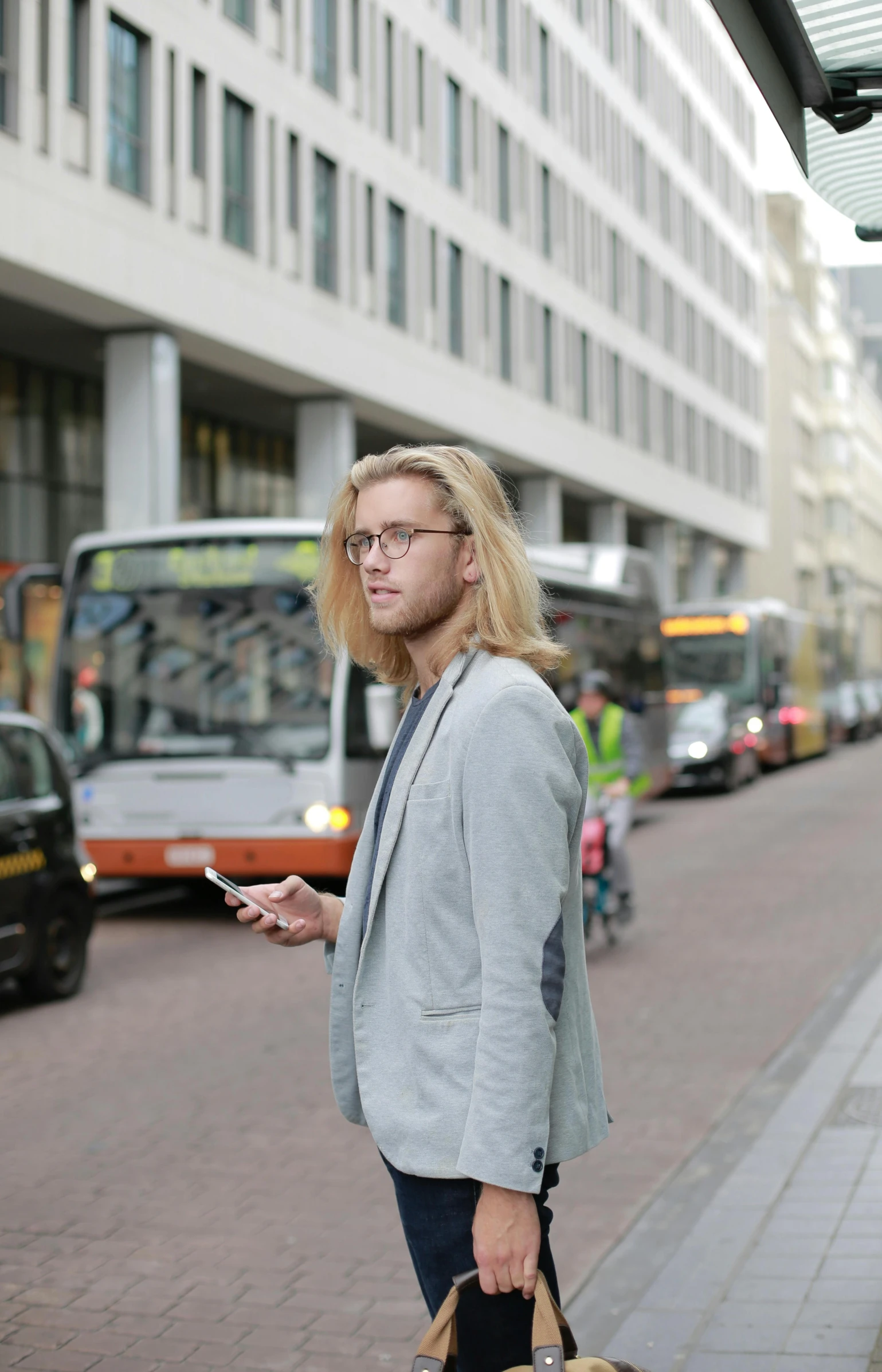 a man with glasses is on the phone and looking at his purse