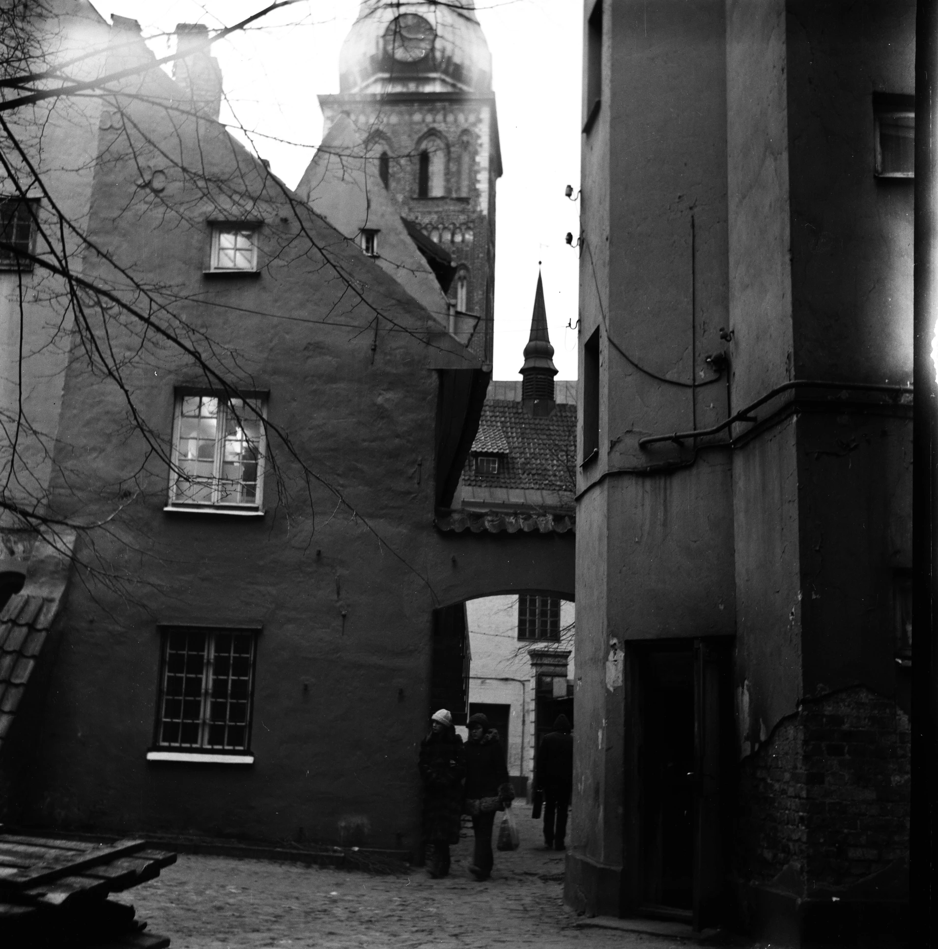 an old time city street with a steeple and people