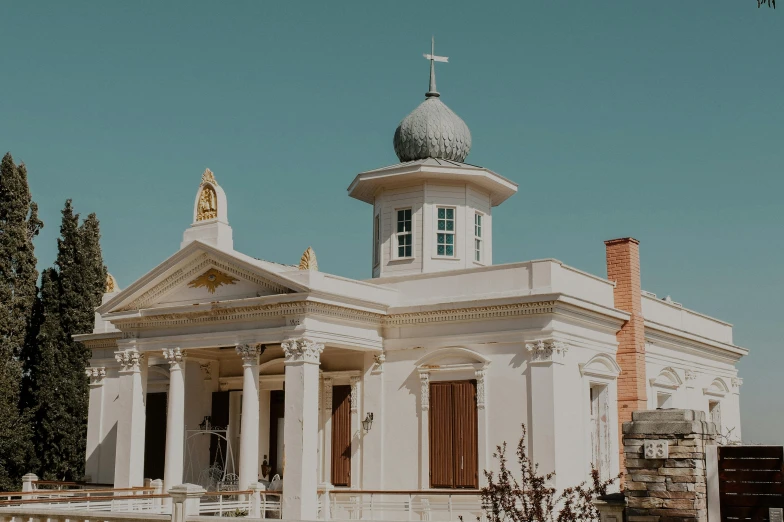 a white church that has pillars and a steeple