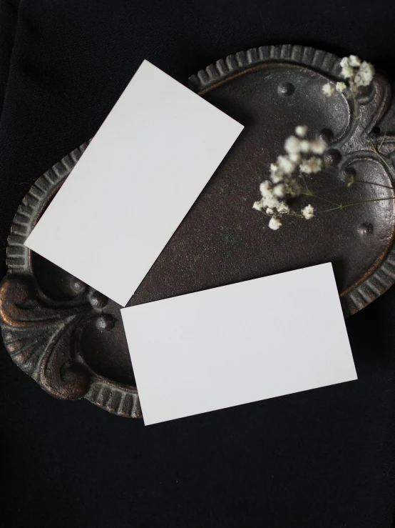 a pair of white cards sitting on top of a metal plate