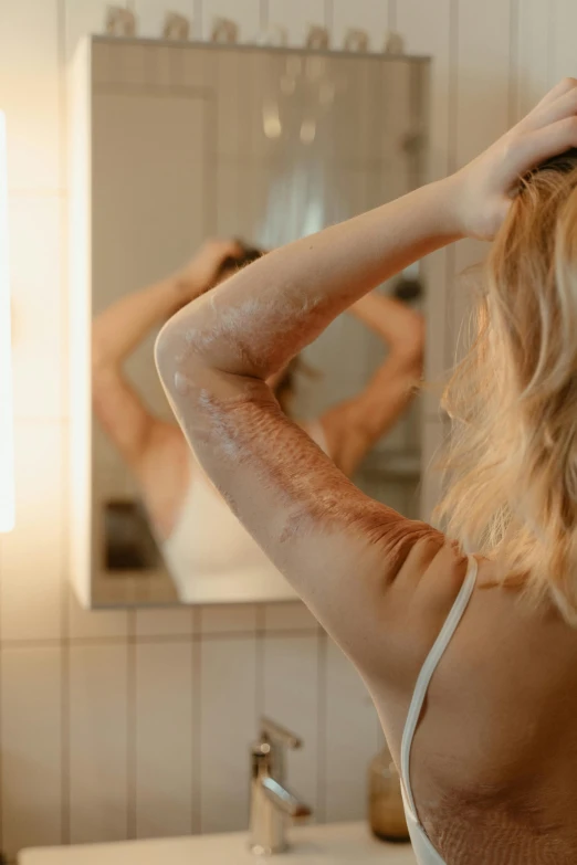 the woman is trying on her hair in the bathroom