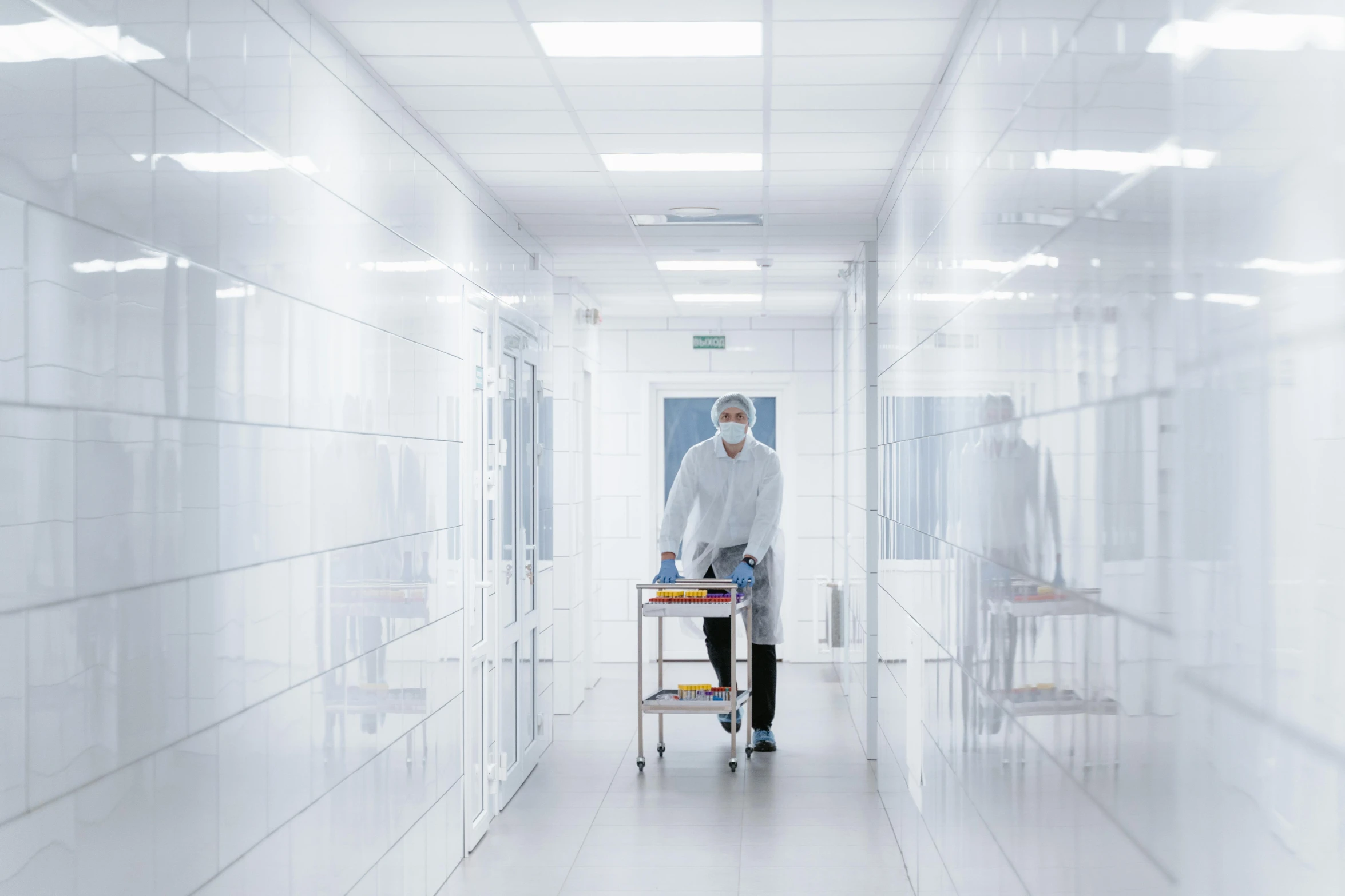 a man in white coat walking down the hallway