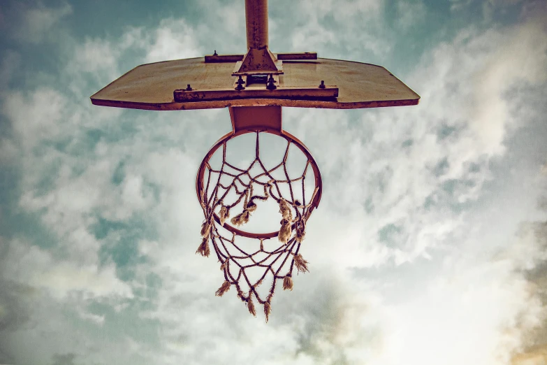 a basketball going through the hoop on a sunny day