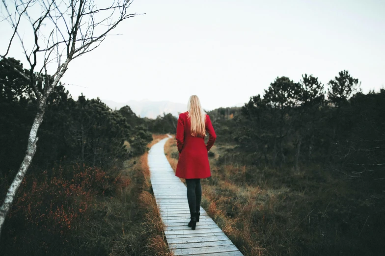 the woman is walking down the pathway towards the camera