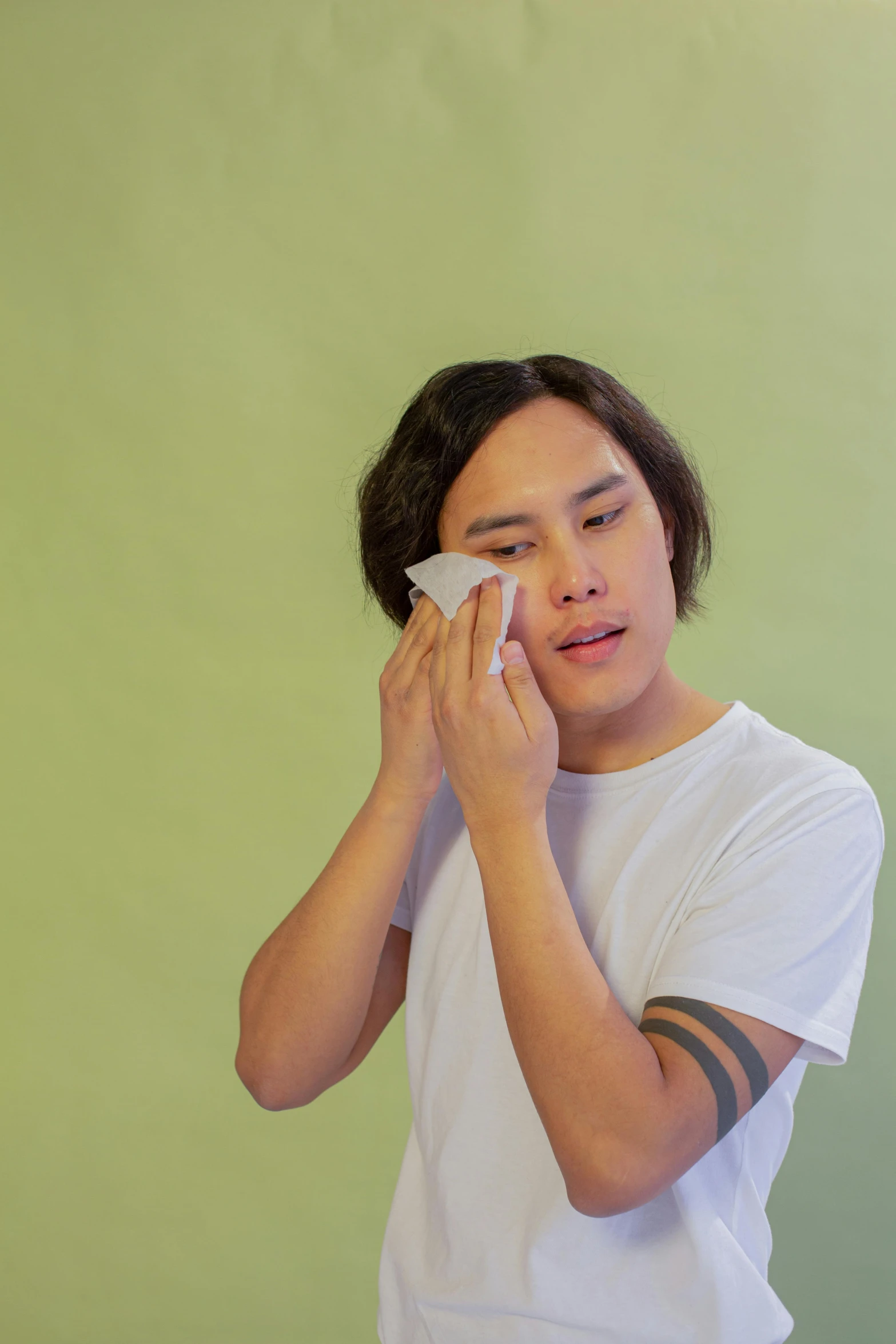 a man that is holding a tissue in his hand