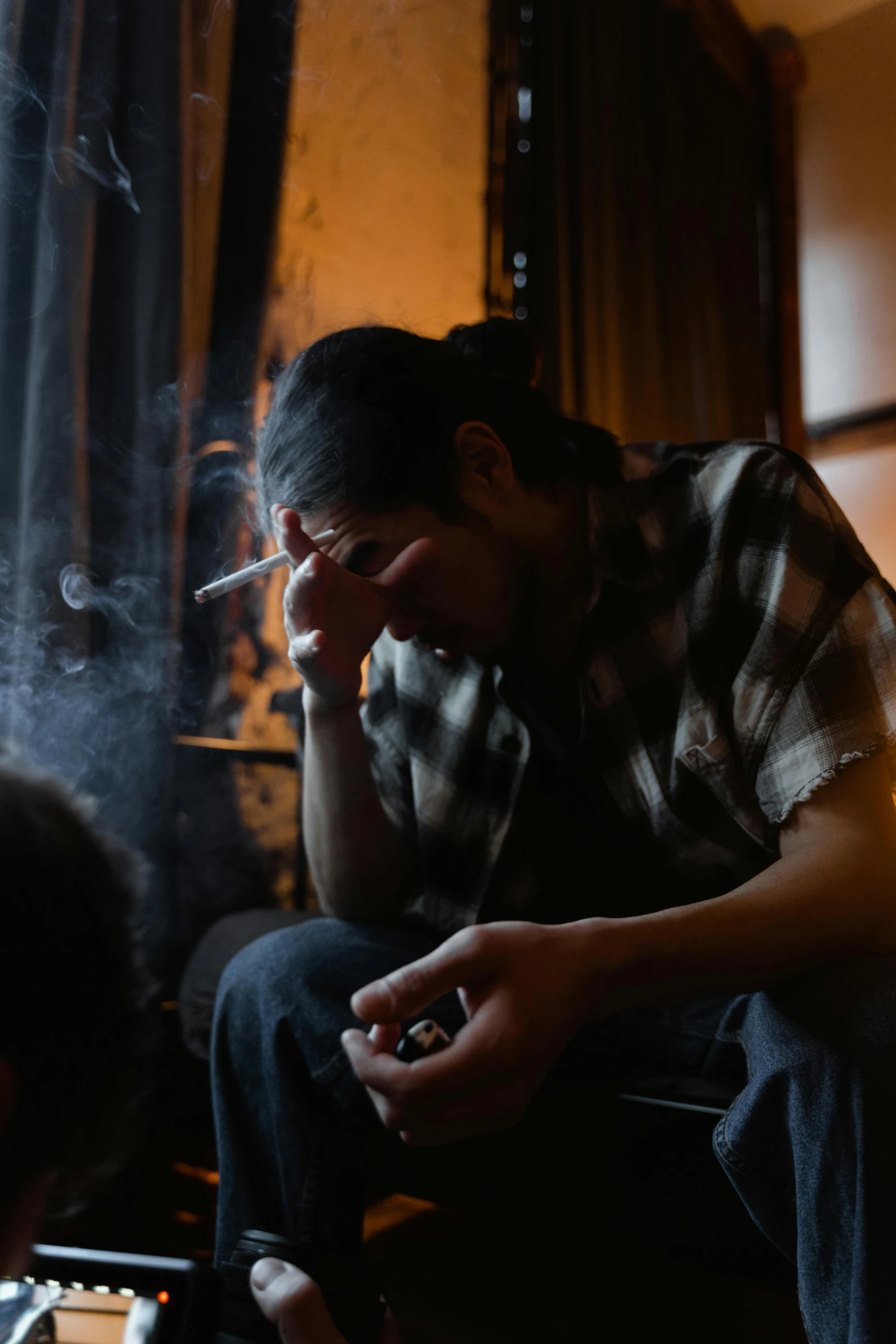 a man smoking a cigarette and looking down