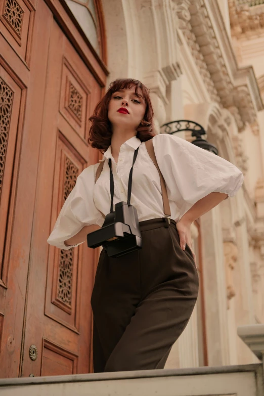 a woman stands on the outside of a building wearing a suspender