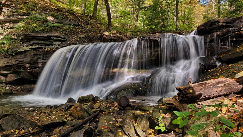 a large waterfall is shown in the woods