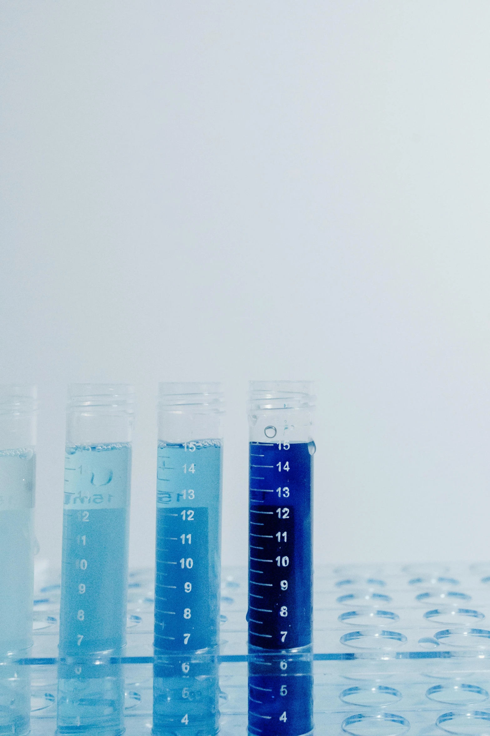 four beakle of water on top of a table with glassware in it