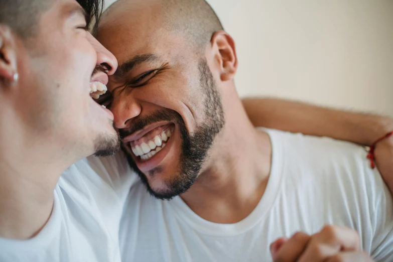 two males are laughing and hugging each other