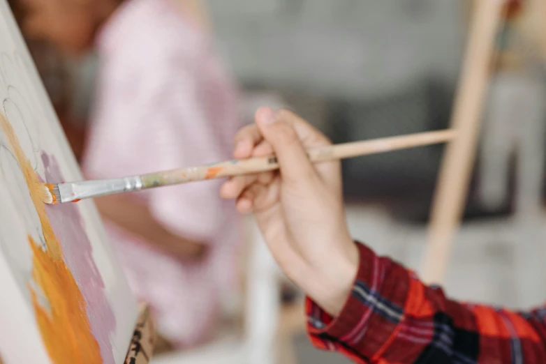 a child is holding a paintbrush and painting