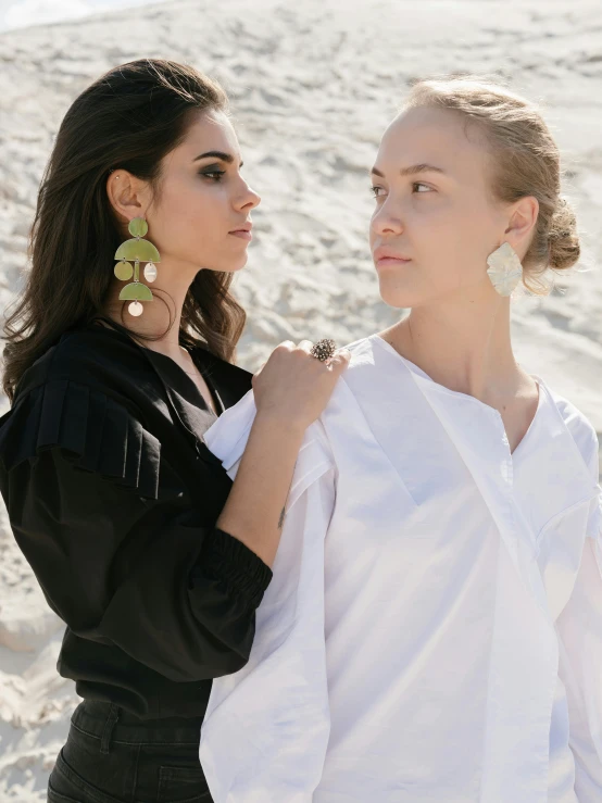 a couple of women standing next to each other on a beach