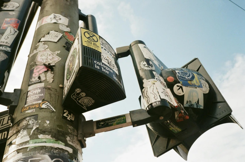 a street sign covered in lots of stickers