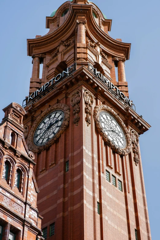 an elaborate brick clock tower with a sky background