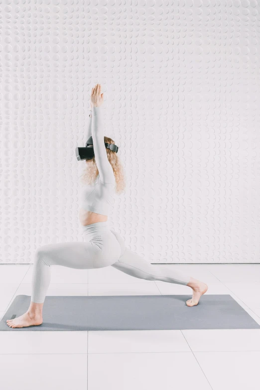 a woman practicing yoga poses in front of a backdrop