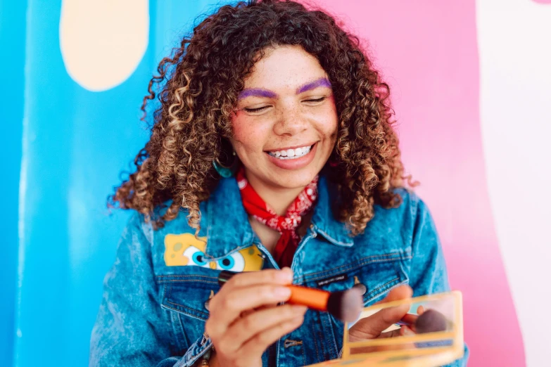 a woman with eye make up holds up an item