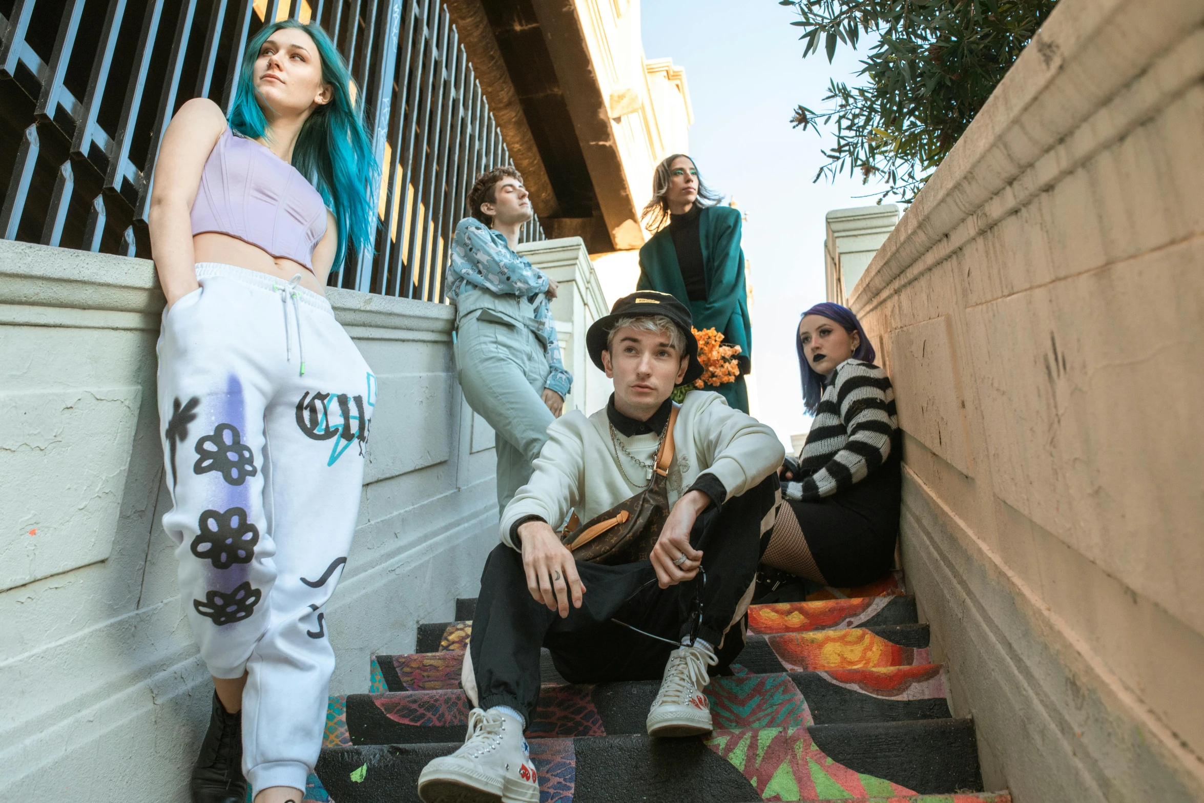 young people sitting on the steps outside of a building