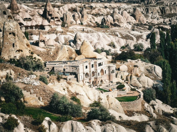 an old building surrounded by rocky terrain in an area with dry vegetation