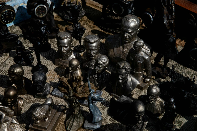 a bunch of antique statue heads sit on a table