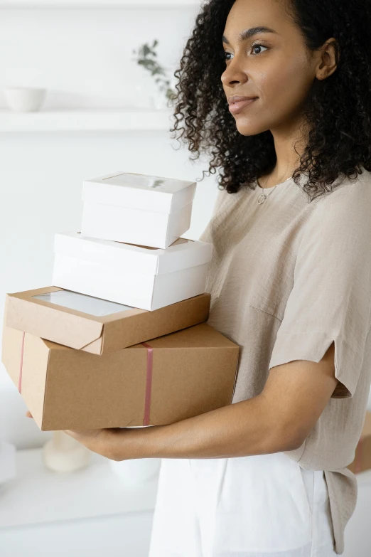 a woman holding a stack of boxes on her chest