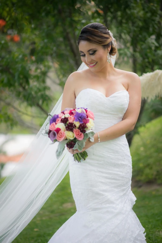 a bride holds a bouquet while outside