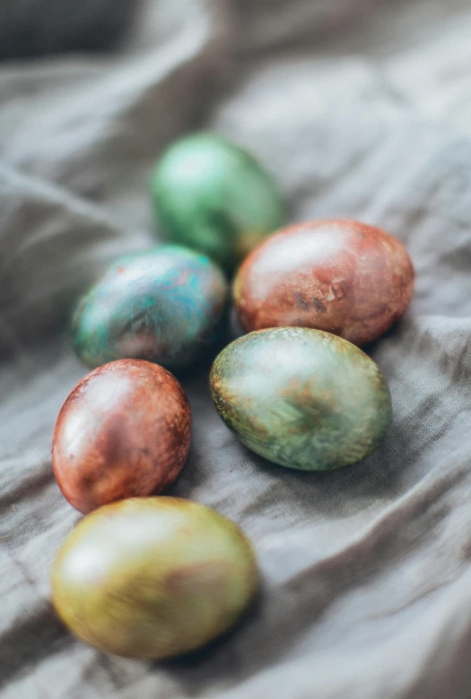 small group of different colored eggs on a linen surface