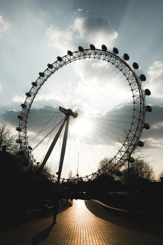 a ferris wheel in front of a bright sun