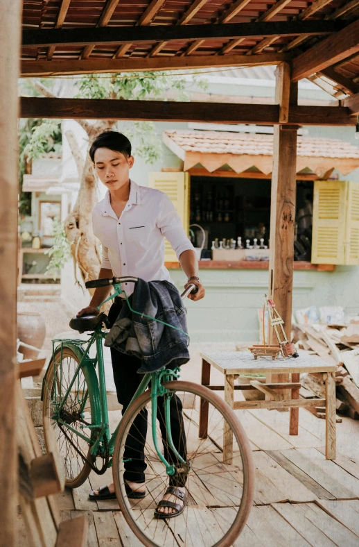 a woman standing next to a green bike