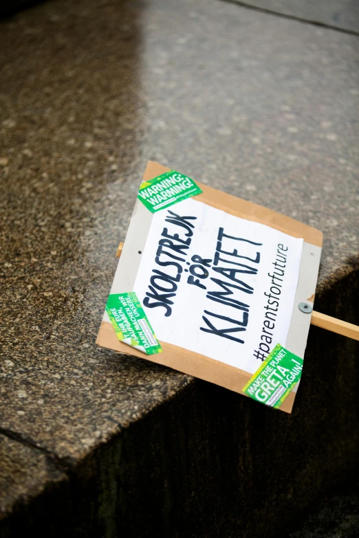 a small wooden stick laying next to a sign