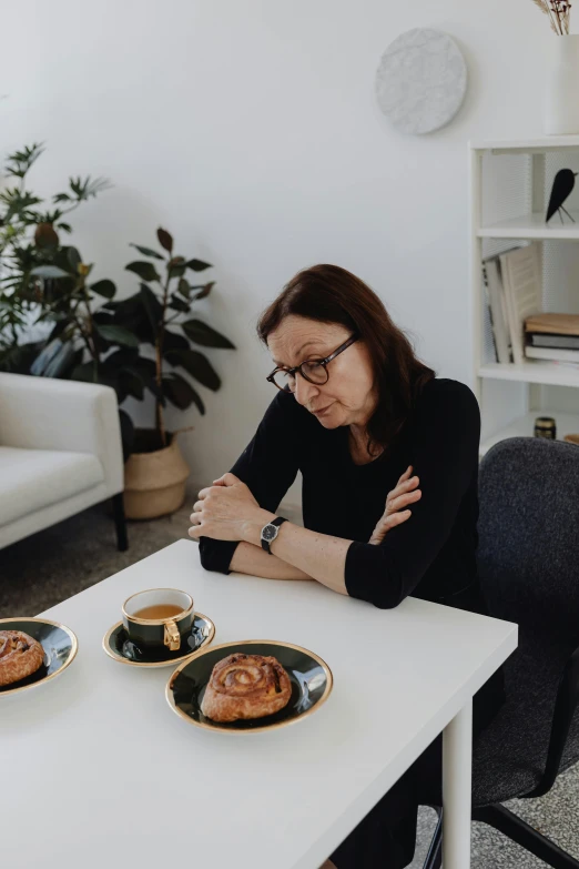 a woman sitting at a table with two plates of food