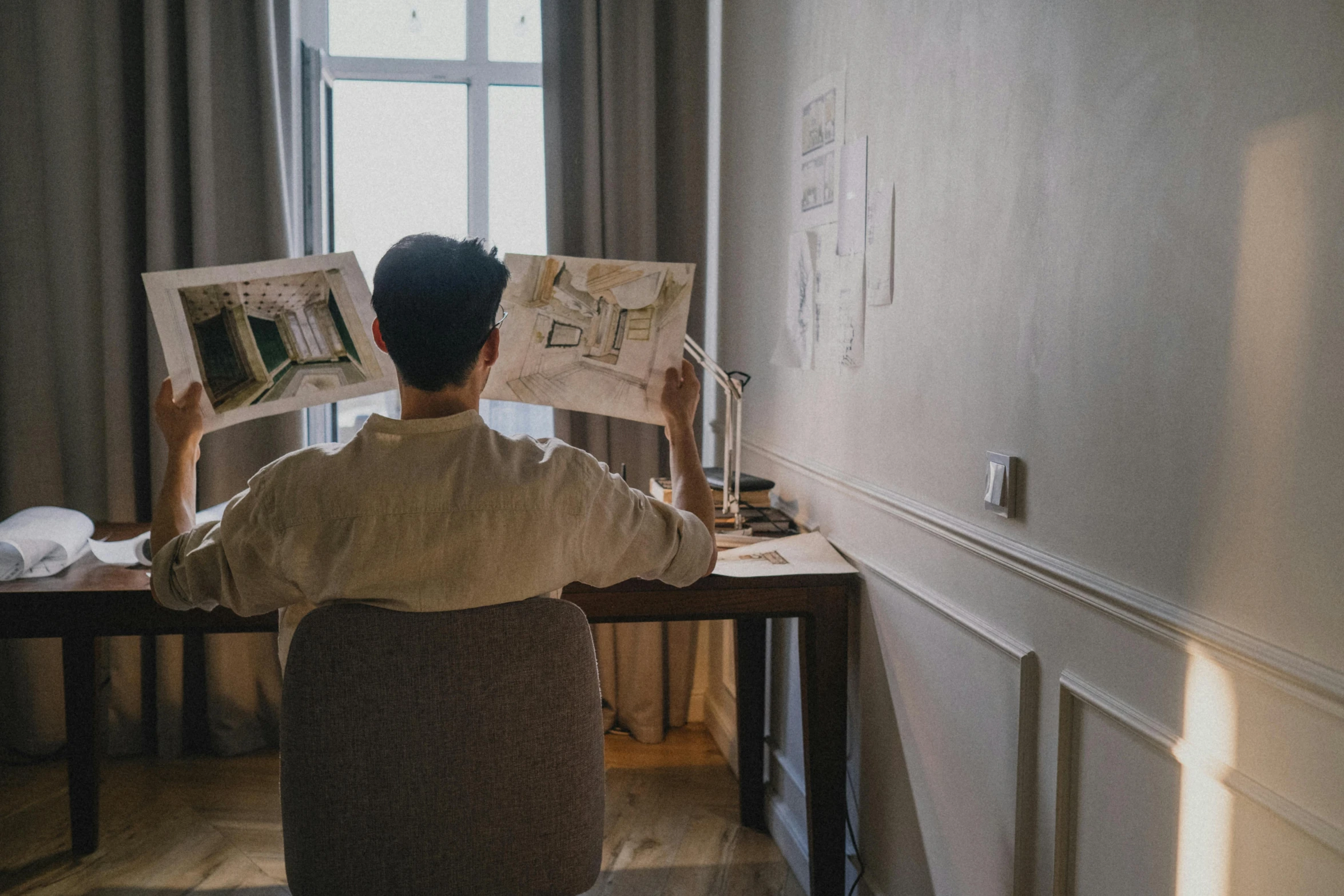 a person sits down and looking at drawings