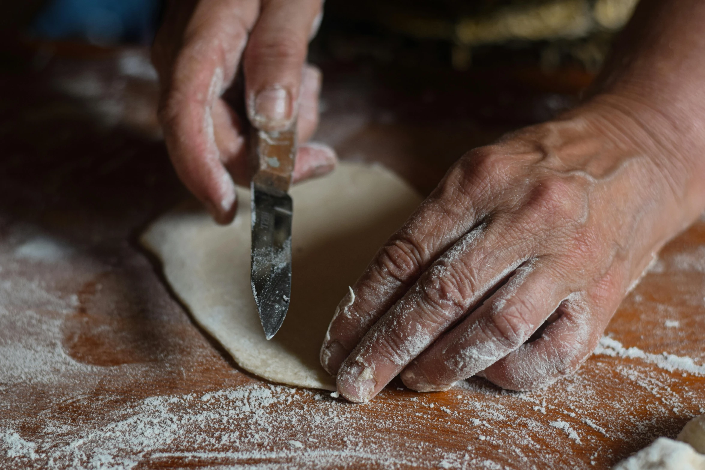 a person who is making dough with a knife