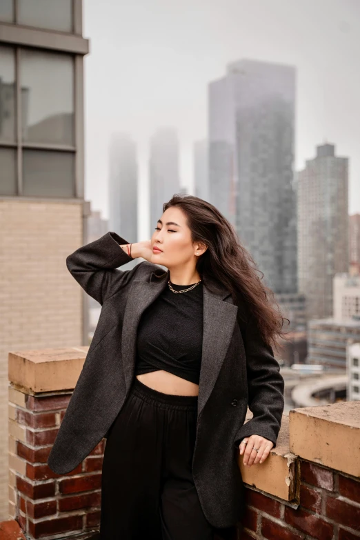 a woman poses in front of an urban skyline