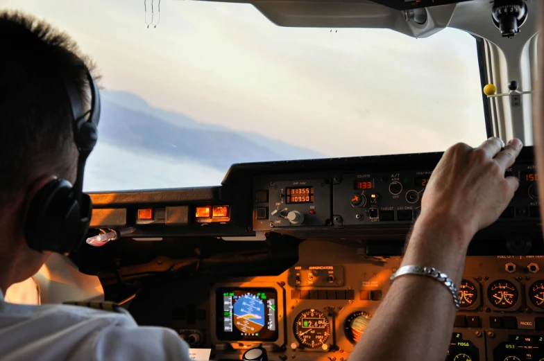 a man talking on a headset sitting in the cockpit of a small plane
