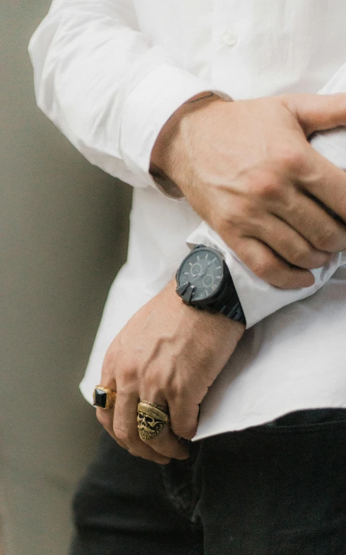 closeup of hand wearing two wrist watches and black dress pants