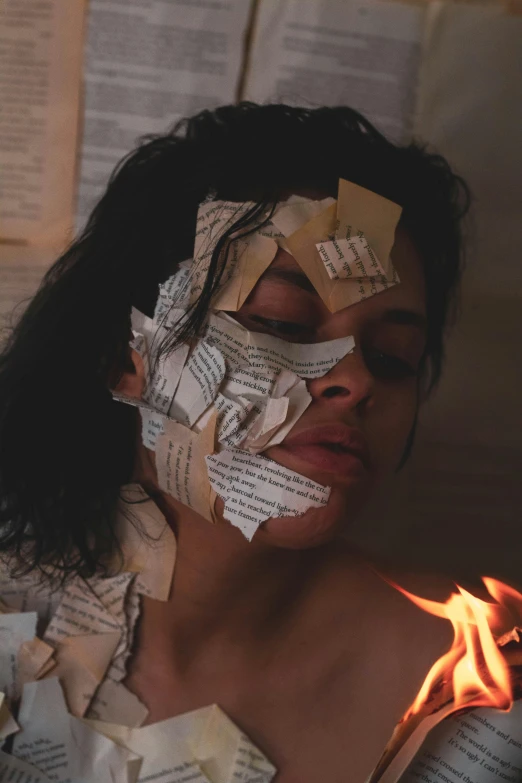 a girl has been partially cut up and has her face taped to fire paper