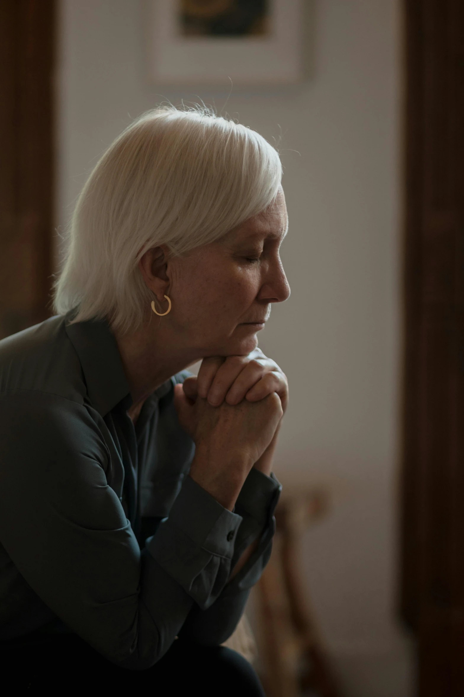 a woman with short white hair is sitting and looking away