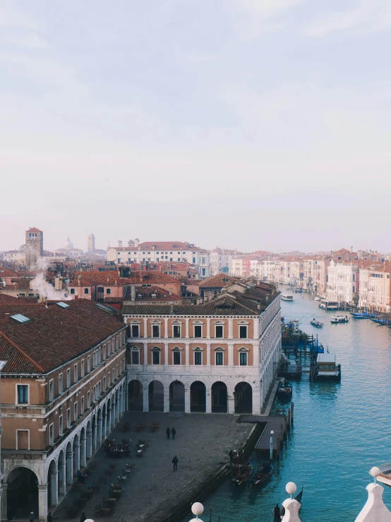 a waterway with buildings and bridges with people sitting on the edge